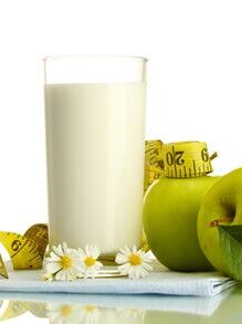 Glass of kefir, green apples and measuring tape isolated